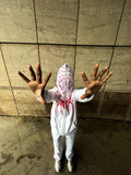 Person wearing a Spider-Man costume with a hood against a tiled wall.